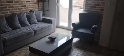 a living room with a couch and a chair and a coffee table at Budva stan Natasa in Budva