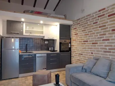 a living room with a couch and a kitchen at Budva stan Natasa in Budva