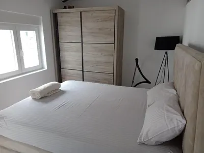 a bedroom with a white bed with a window at Budva stan Natasa in Budva