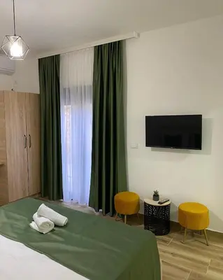 a bedroom with a bed and a flat screen tv at Xhan Apartments in Ulcinj