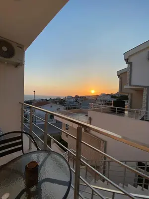 a balcony with a table and a view of the sunset at Xhan Apartments in Ulcinj