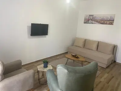 a living room with a couch and a tv at Xhan Apartments in Ulcinj