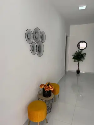 a room with two chairs and a table and a clock at Xhan Apartments in Ulcinj