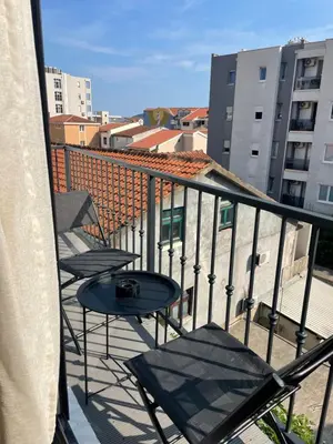 a balcony with two tables and chairs on a building at Lolo Luxury rooms & suites in Budva