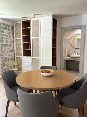 a dining room with a wooden table and chairs at Nest Ozana in Kotor