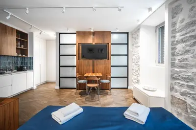 a room with a bed and a tv and a table at Nest Ozana in Kotor