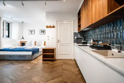 a bedroom with a bed and a kitchen with a sink at Nest Ozana in Kotor