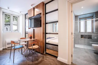 a bathroom with a table and chairs and a bedroom at Nest Ozana in Kotor