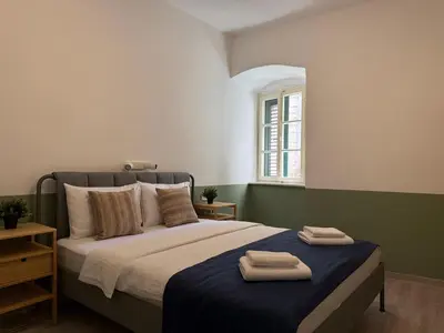 a bedroom with a bed with two towels on it at Nest Ozana in Kotor
