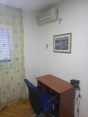 a room with a desk and a blue chair at Stan u maslinama in Podgorica