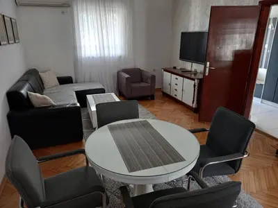 a living room with a table and chairs at Stan u maslinama in Podgorica