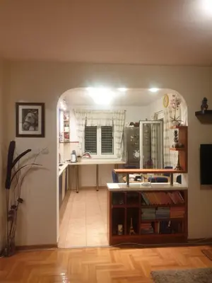 a kitchen with an archway leading into a kitchen with a table at Family apartment Maxema in Budva