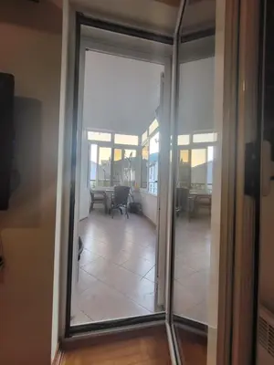 a sliding glass door leading into a room with a table at Family apartment Maxema in Budva
