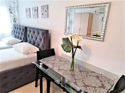 a bedroom with a bed and a table with a mirror at Montenegro Smile in Dobra Voda