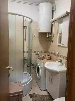 a bathroom with a shower sink and a washing machine at Mountain house Ivanova Korita in Cetinje