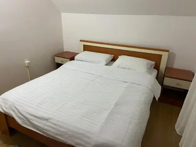 a bedroom with a large white bed with two pillows at Mountain house Ivanova Korita in Cetinje