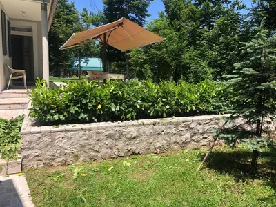 an umbrella sitting on top of a stone wall at Mountain house Ivanova Korita in Cetinje