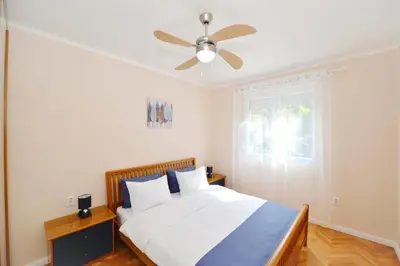 a bedroom with a bed with a ceiling fan at Unico apartman in Kotor