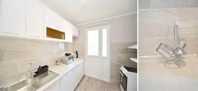 a kitchen with white cabinets and a sink at Unico apartman in Kotor