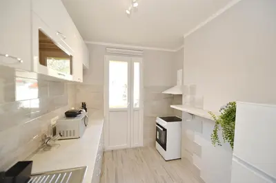 a kitchen with white walls and a white stove at Unico apartman in Kotor