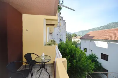 a balcony with a table and chairs on a building at Unico apartman in Kotor