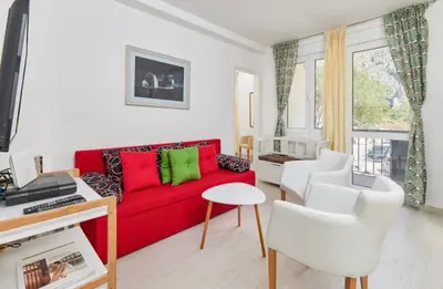 a living room with a red couch and white chairs at Apartment Pavle in Kotor