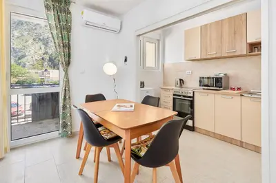 a kitchen and dining room with a wooden table and chairs at Apartment Pavle in Kotor