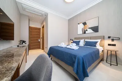 a hotel room with a bed with a blue blanket at C Group apartments in Kotor