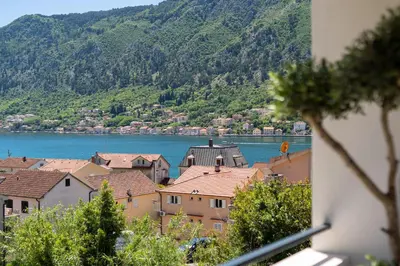 a view of a town with a lake and mountains at C Group apartments in Kotor
