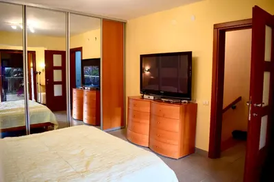 a bedroom with a bed and a television on a dresser at Family Villa in Petrovac na Moru