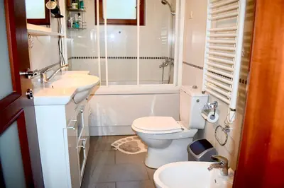 a bathroom with a toilet and a sink and a shower at Family Villa in Petrovac na Moru