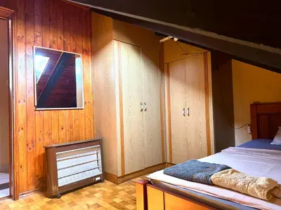 a bedroom with a bed and wooden walls and a window at KotorHostelito in Kotor