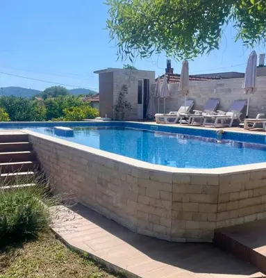 a large swimming pool with chairs and umbrellas at Villa Nilić in Bar
