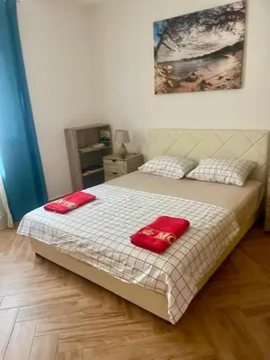 a bedroom with a bed with two red towels on it at Villa Nilić in Bar