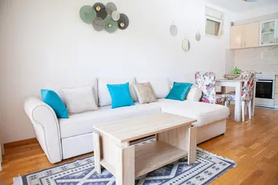 a living room with a white couch and a table at Apartments LORA Cetinjska18 in Budva