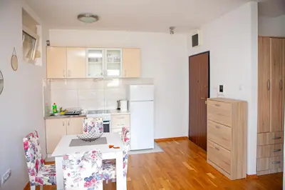 a kitchen with a table and chairs in a room at Apartments LORA Cetinjska18 in Budva