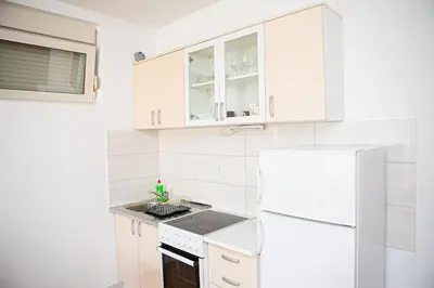 a kitchen with white cabinets and a white refrigerator at Apartments LORA Cetinjska18 in Budva
