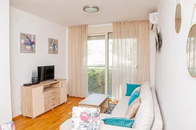 a living room with a white couch and a window at Apartments LORA Cetinjska18 in Budva