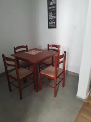 a wooden table with two chairs and a table and a chalkboard at Dominik in Bar