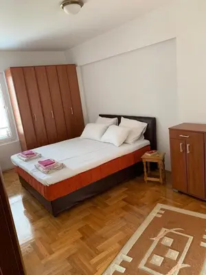 a bedroom with a bed with a wooden headboard at Apartment IDA in Budva