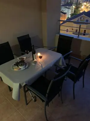 a table with a plate of food and a bottle of wine at Apartment IDA in Budva