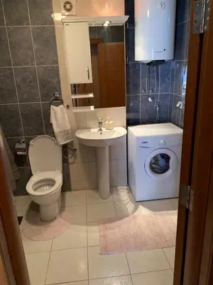 a bathroom with a toilet sink and a washing machine at Apartment IDA in Budva