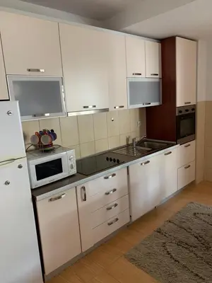 a kitchen with white cabinets and white appliances at Apartment IDA in Budva
