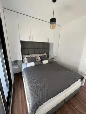 a bedroom with a large bed and white cabinets at APARTMENT DZANA in Dobra Voda