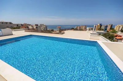 a blue swimming pool on the roof of a building at APARTMENT DZANA in Dobra Voda