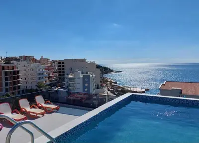 a swimming pool with chairs and a view of the ocean at APARTMENT DZANA in Dobra Voda