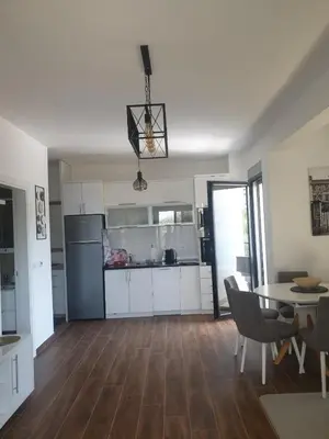 a kitchen and dining room with a table and chairs at APARTMENT DZANA in Dobra Voda