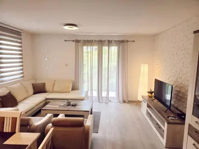 a living room with a couch and a tv at A&A Apartment in Blue Horizon Przno with pool in Budva