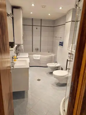 a bathroom with two sinks and a toilet and a tub at A&A Apartment in Blue Horizon Przno with pool in Budva