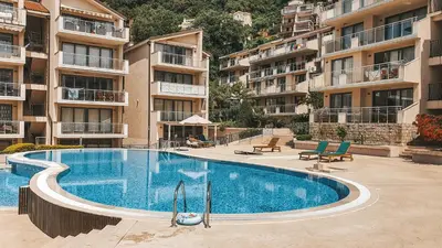 a swimming pool in front of some apartment buildings at A&A Apartment in Blue Horizon Przno with pool in Budva